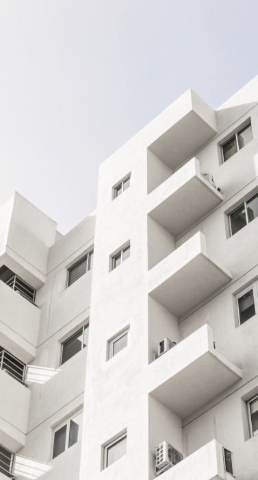 low-angle-shot-facade-white-modern-building-blue-clear-sky