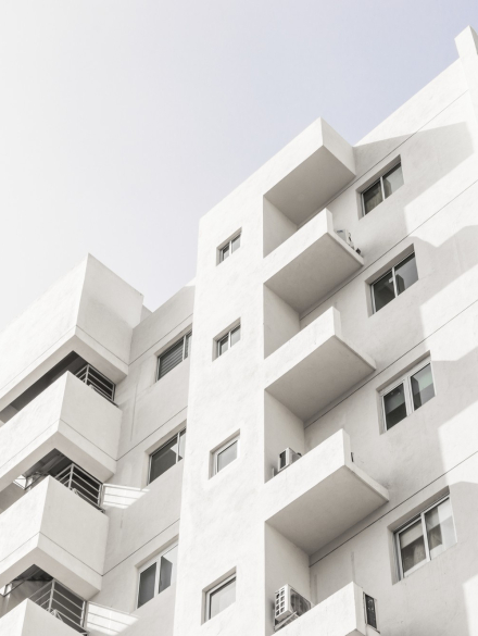 low-angle-shot-facade-white-modern-building-blue-clear-sky